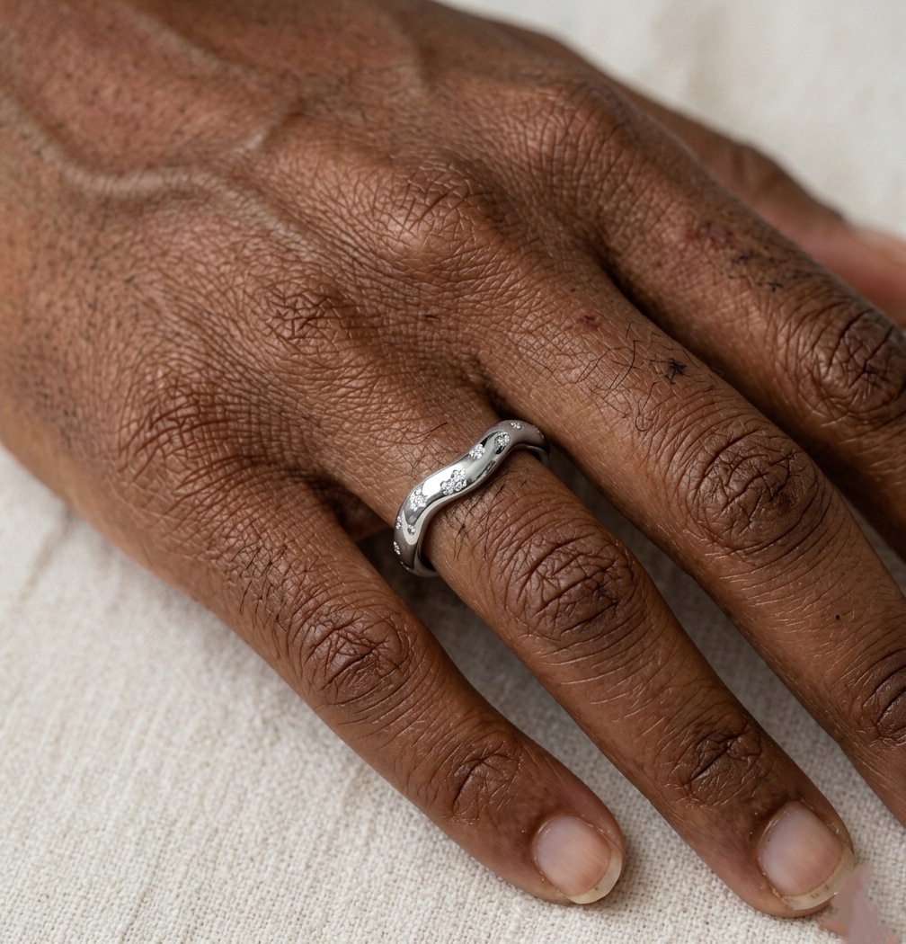 Bague Zoé argentée en acier inoxydable avec design vague martelée portée à l'annulaire.