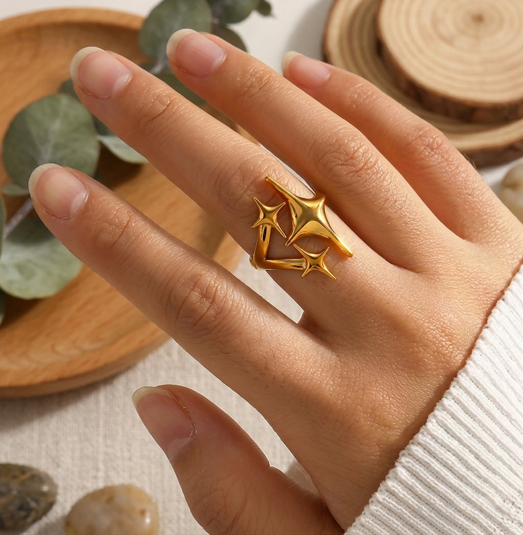 Bague Cassiopée Filante Or Solaire portée au doigt par une mannequin, pull en maille blanc.