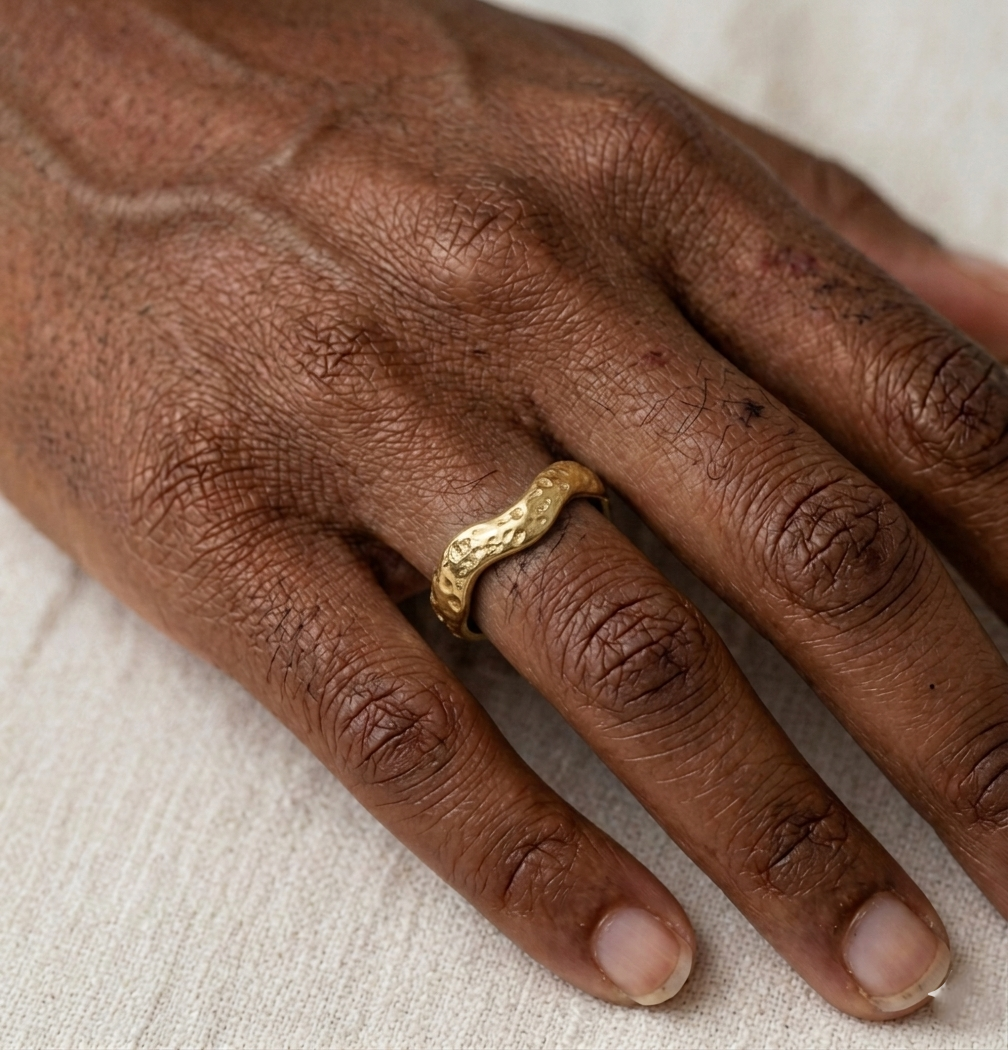 Bague Zoé dorée en acier inoxydable avec design vague martelée portée à l'annulaire.