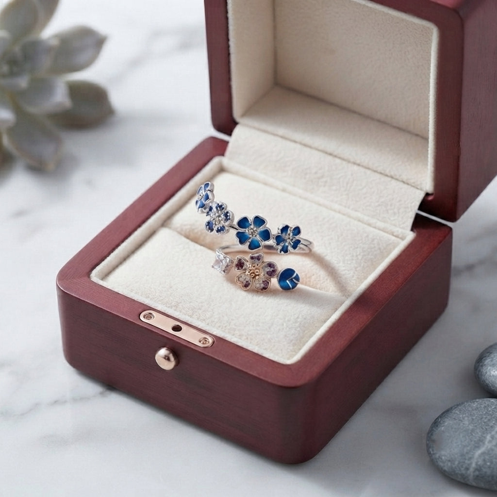 Bague fleur de pêcher argentée élégamment disposée dans son écrin en bois sombre.