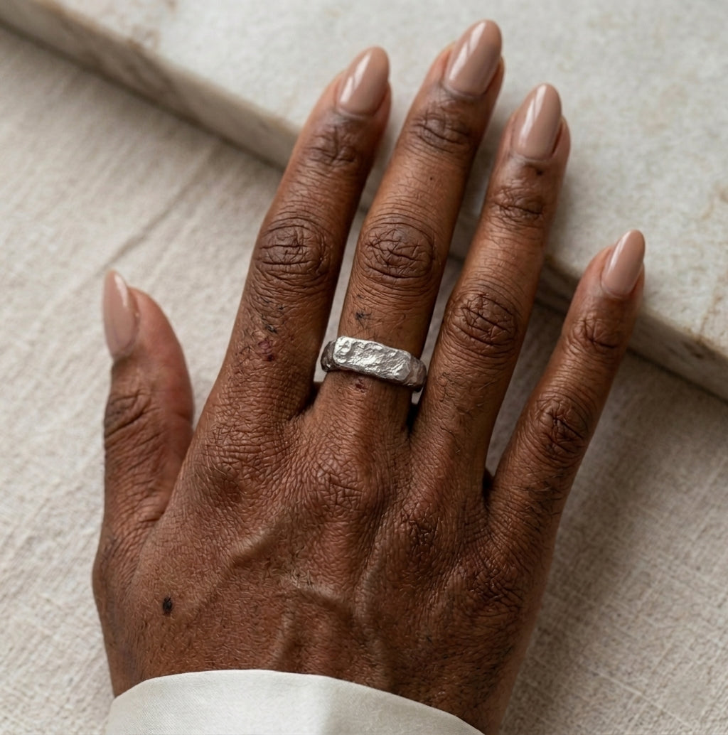 Gros plan d'une main avec la bague Gabrielle Indomptable en argent texturé, design brut.