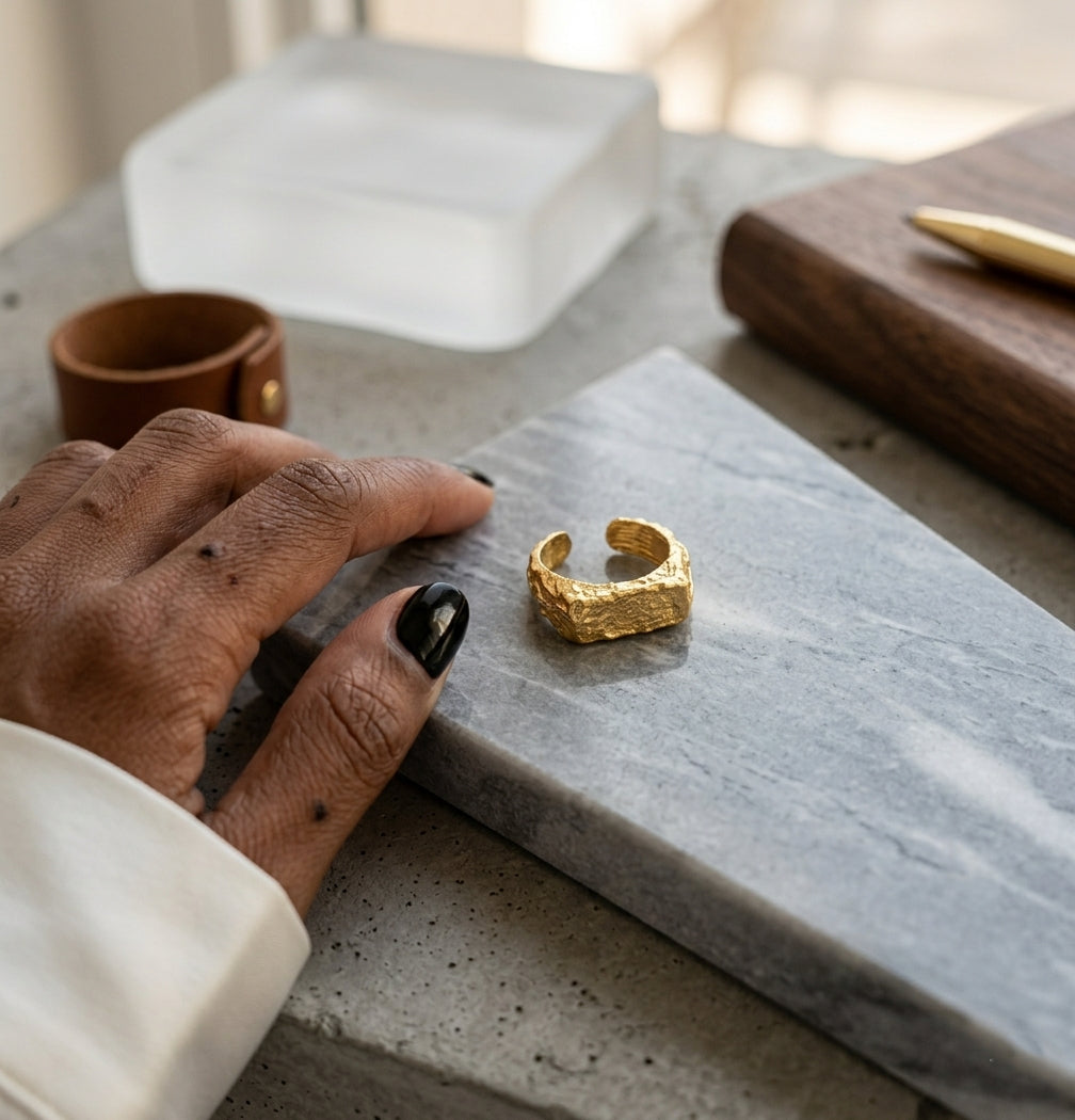 Bague Gabrielle Indomptable doré texturé portée sur une main avec manucure noire.