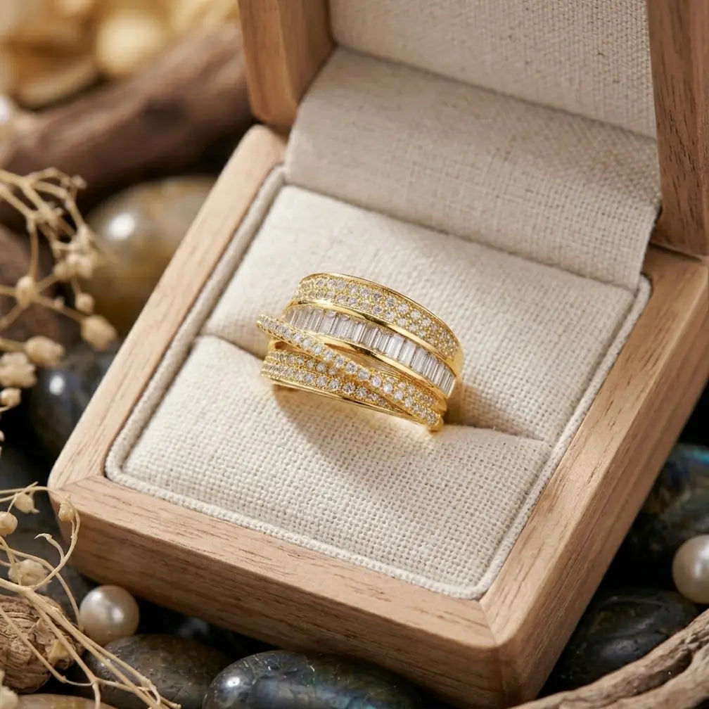 Gros plan de la bague dorée Soline sertie de brillants dans son coffret en bois, acier inoxydable.