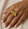 Gros plan d'une main de femme portant la bague Pétale dorée, mettant en avant son design floral et ses détails ciselés.