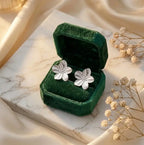 Boucles d'oreilles Léonie Majestueuse en argent présentées dans un écrin de luxe en velours vert émeraude. Le coffret est posé sur du marbre, accompagné de fleurs de gypsophile séchées pour une ambiance romantique.