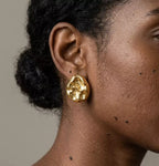 Présentation luxueuse des boucles d'oreilles Léna - Aquatique dorées dans un écrin haut de gamme ouvert sur un tissu de soie.