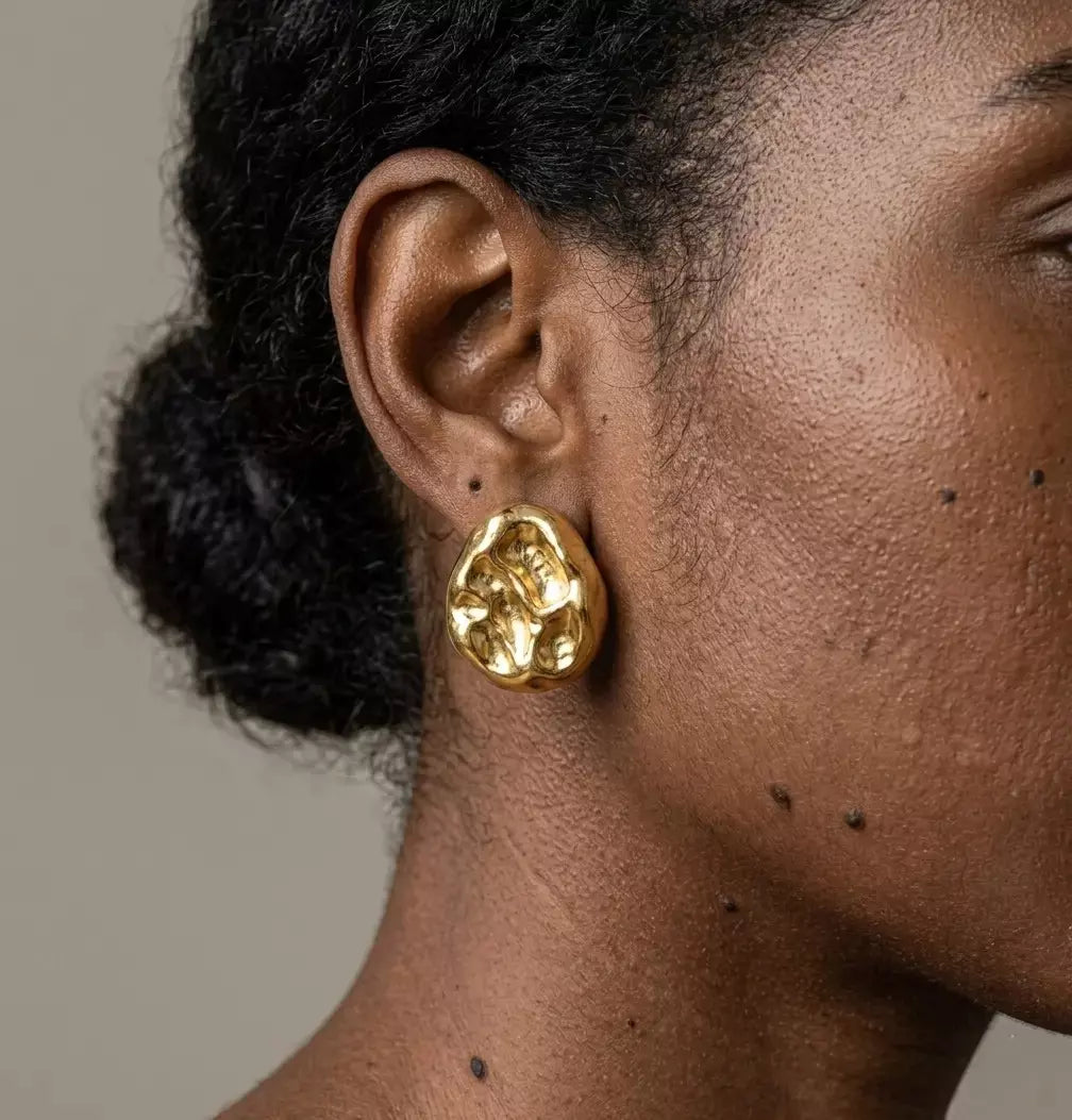 Présentation luxueuse des boucles d'oreilles Léna - Aquatique dorées dans un écrin haut de gamme ouvert sur un tissu de soie.