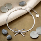 Zoom sur les détails du bracelet argenté Thalya - Noué. L'alliance parfaite d'une maille serpent fluide et d'un nœud central raffiné au style unique.