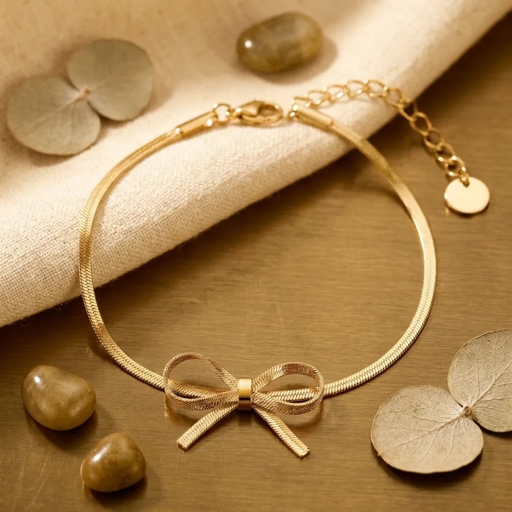 Zoom sur les détails du bracelet doré Thalya - Noué. L'alliance parfaite d'une maille serpent fluide et d'un nœud central raffiné au style unique.