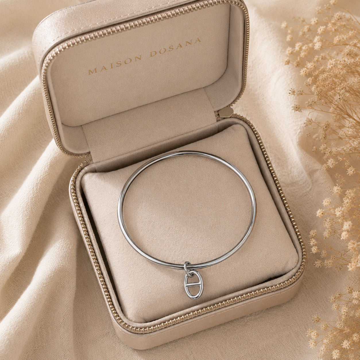 Bracelet jonc Stella en argent avec charm maille marine présenté dans son coffret à bijoux beige siglé Maison Dosana.
