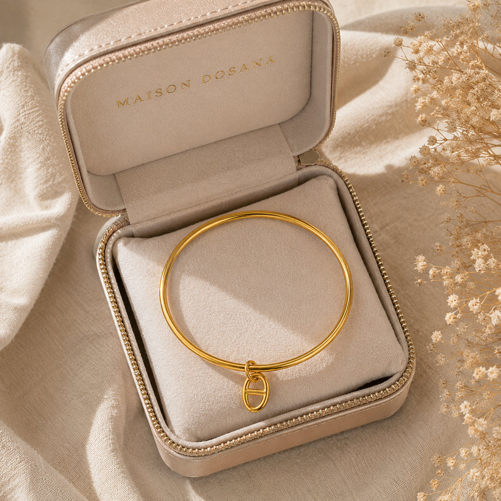 Bracelet jonc Stella en argent avec charm maille marine présenté dans son coffret à bijoux beige siglé Maison Dosana.