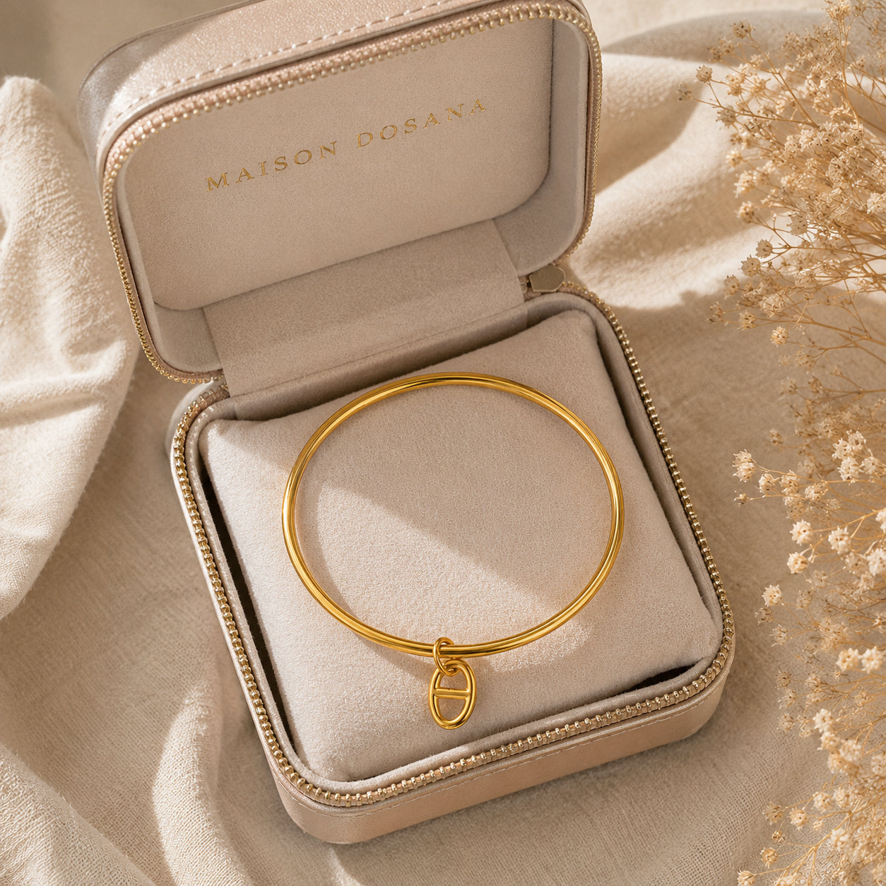Bracelet jonc Stella en argent avec charm maille marine présenté dans son coffret à bijoux beige siglé Maison Dosana.