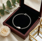 Bracelet Marine Sauvage en acier inoxydable argenté avec perles baroques dans son écrin de luxe en bois sombre.