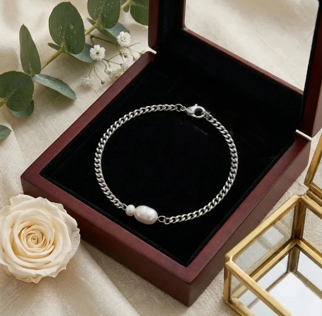 Bracelet Marine Sauvage en acier inoxydable argenté avec perles baroques dans son écrin de luxe en bois sombre.