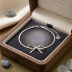 Offrez le cadeau idéal avec le bracelet argenté Thalya - Noué, présenté dans son joli écrin en bois. Une attention raffinée pour toutes les occasions.