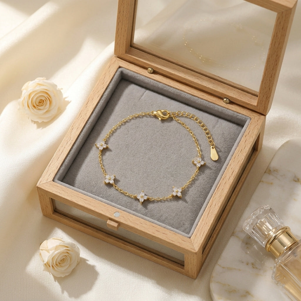 Vue plongeante du bracelet doré Margaux Fine parfaitement disposé à l'intérieur d'un écrin de luxe en bois clair ouvert. L'intérieur en velours gris perle fait ressortir l'éclat des cristaux et la finition dorée de la chaînette de réglage et de son fermoir mousqueton.