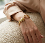 Bracelet doré Lyra - Aérienne porté au poignet, une pièce "statement" aux courbes élégantes et à la finition dorée brillante.