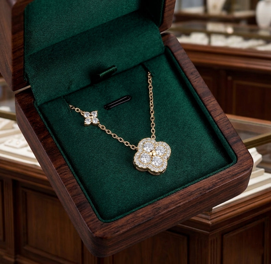 e collier Livia Radieuse doré présenté dans un écrin de luxe en bois précieux avec intérieur en velours vert émeraude.