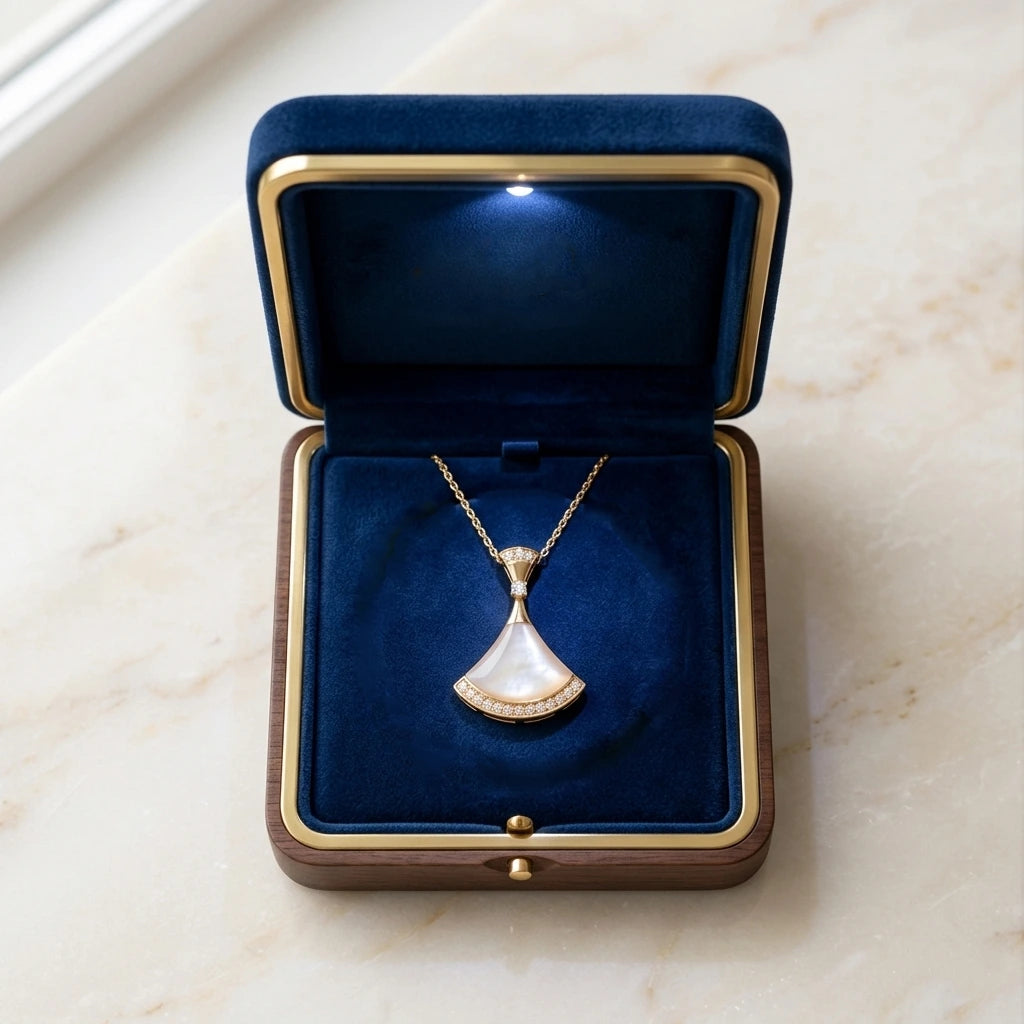Pendentif éventail en or et nacre Christelle la Précieuse présenté dans son écrin de luxe en velours bleu nuit avec éclairage LED.