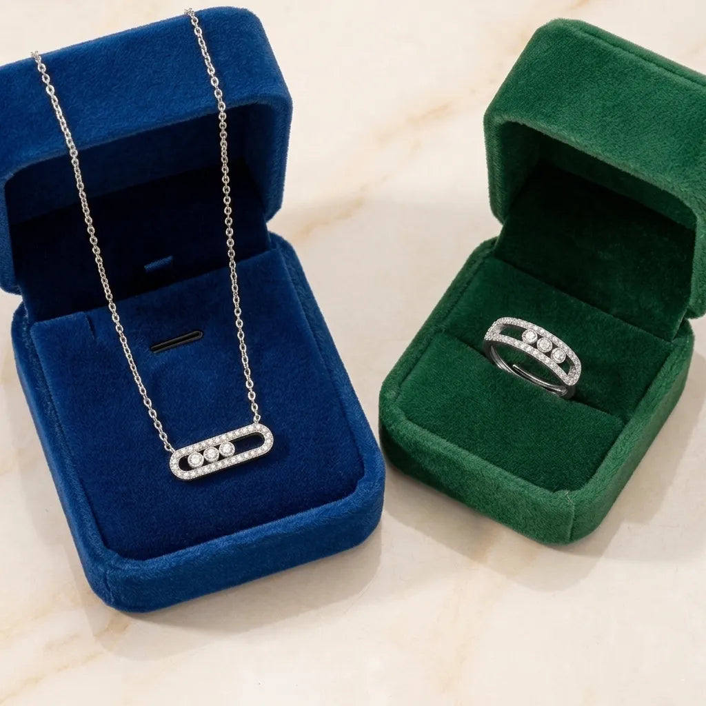 Collier argenté dans un écrin de velours bleu et bague argentée dans un écrin vert, présentation de luxe pour la parure Sacha l'Instinctive.