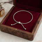 Le bijou de cheville Sienne Infinie argenté présenté dans un coffret en bois précieux doublé de velours bordeaux, une idée cadeau d'exception.