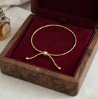 Le bijou de cheville Sienne Infinie doré présenté dans un coffret en bois précieux doublé de velours bordeaux, une idée cadeau d'exception.