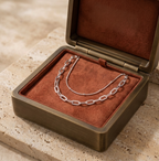 Présentation luxueuse du bijou de cheville Maya Doré argenté dans son écrin de velours et métal brossé, idéal pour offrir.