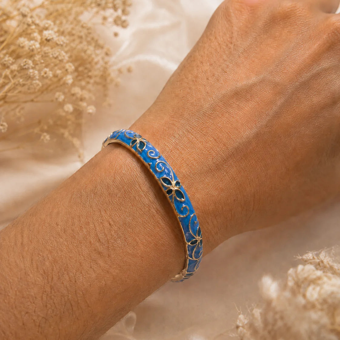 Jonc thaïlandais Sakura bleu royal porté au poignet.