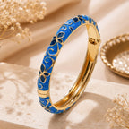 Jonc thaïlandais Sakura bleu royal posé sur un décor élégant en pierre naturelle et fleurs séchées.
