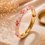 Jonc thaïlandais Sakura rose posé sur un décor élégant en pierre naturelle et fleurs séchées.
