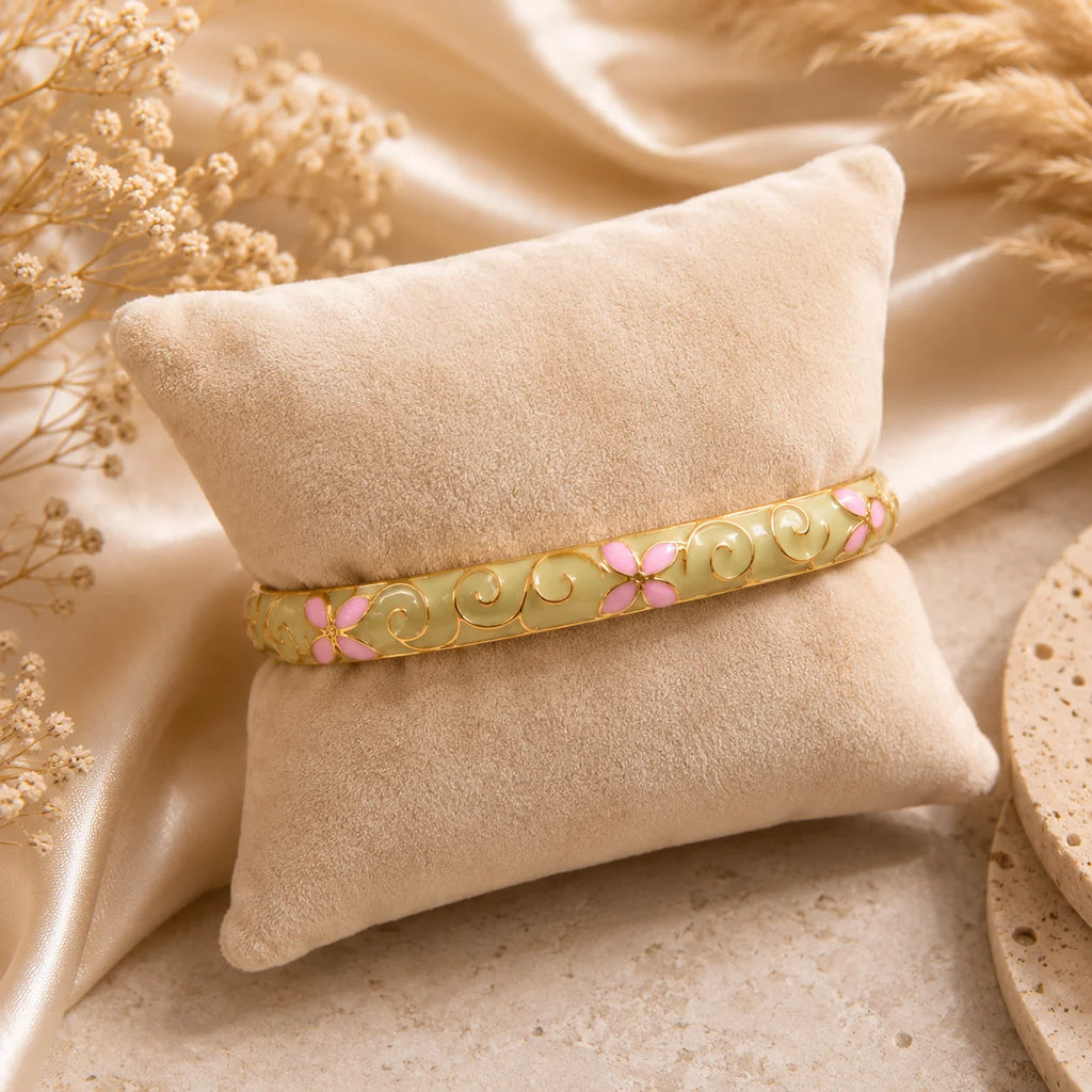 Bracelet jonc thaïlandais Sakura champagne présenté sur un coussin en tissu écru.