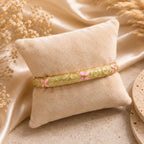 Bracelet jonc thaïlandais Sakura champagne présenté sur un coussin en tissu écru.